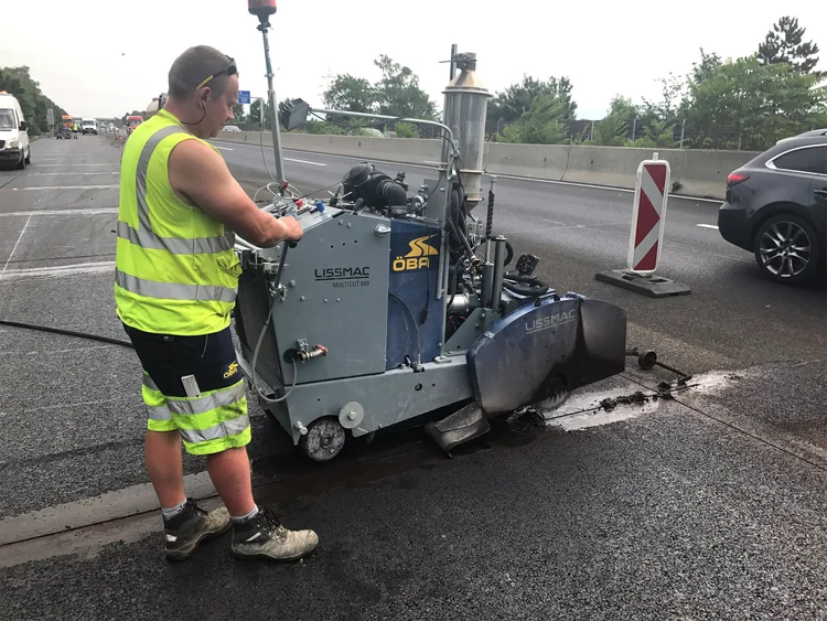 Photo: worker using a joint cutter to create asphalt joints